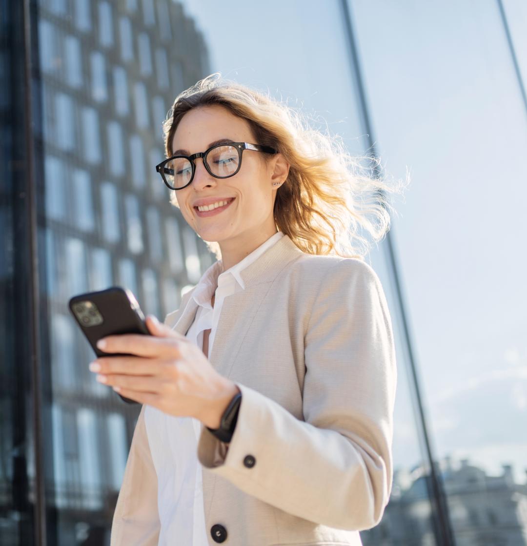 Frau schaut lächelnd auf Handy