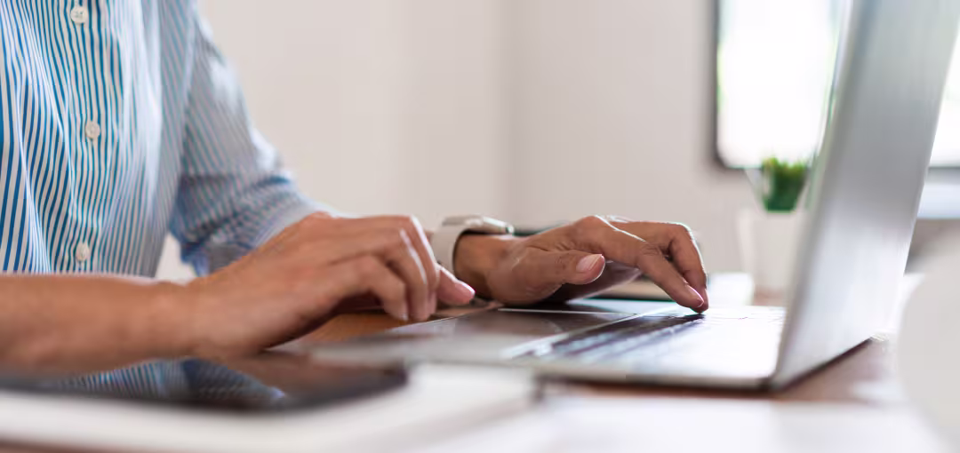 Foto von Person die am Laptop arbeitet und etwas eintippt